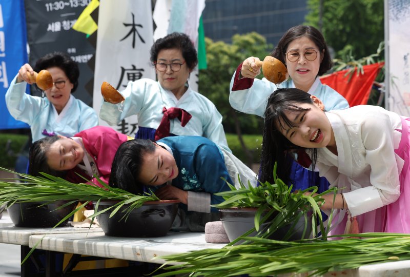 전국단오제연합 회원들이 22일 오전 서울 중구 청계광장에서 열린 '단오, 단 하나가 되다' 홍보제에서 창포물 머리 감기를 시연하고 있다. ⓒ사진 2024년 5월 22일 뉴시스